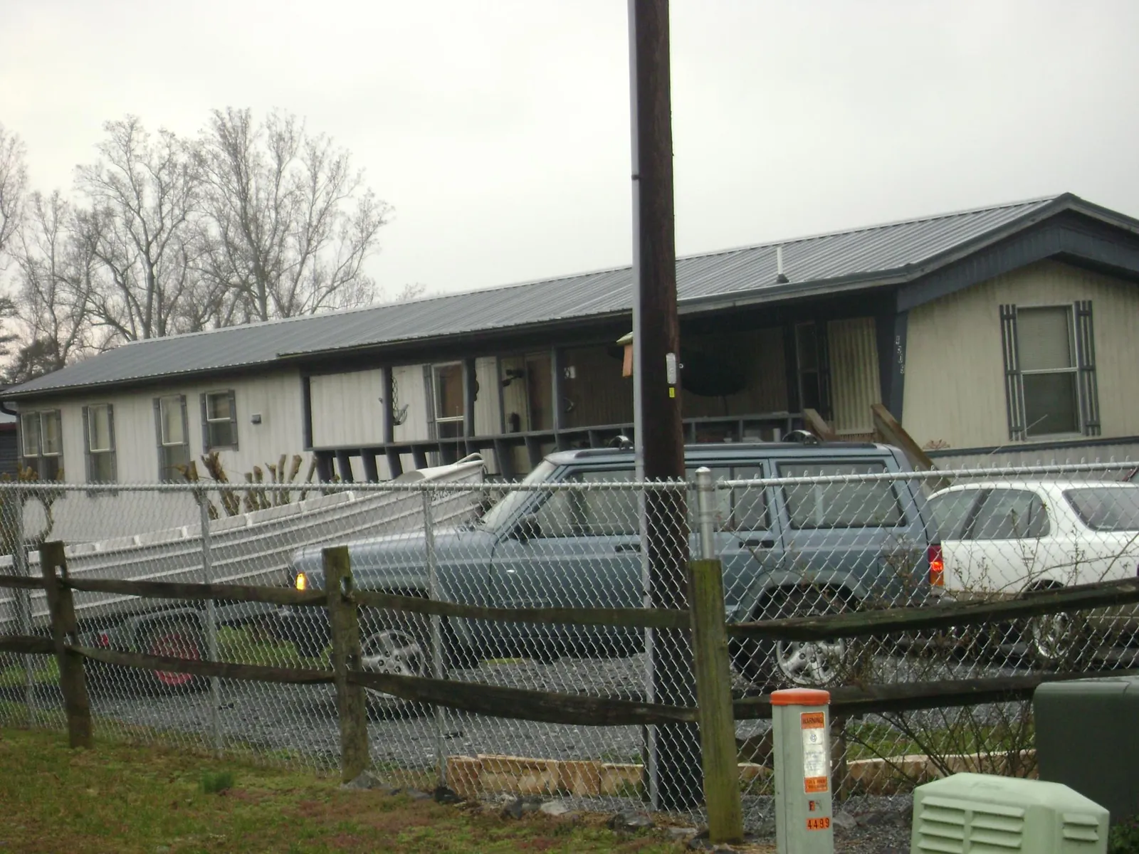 Dark metal roof on a long single story building behind a chain link fence in Bridgeport